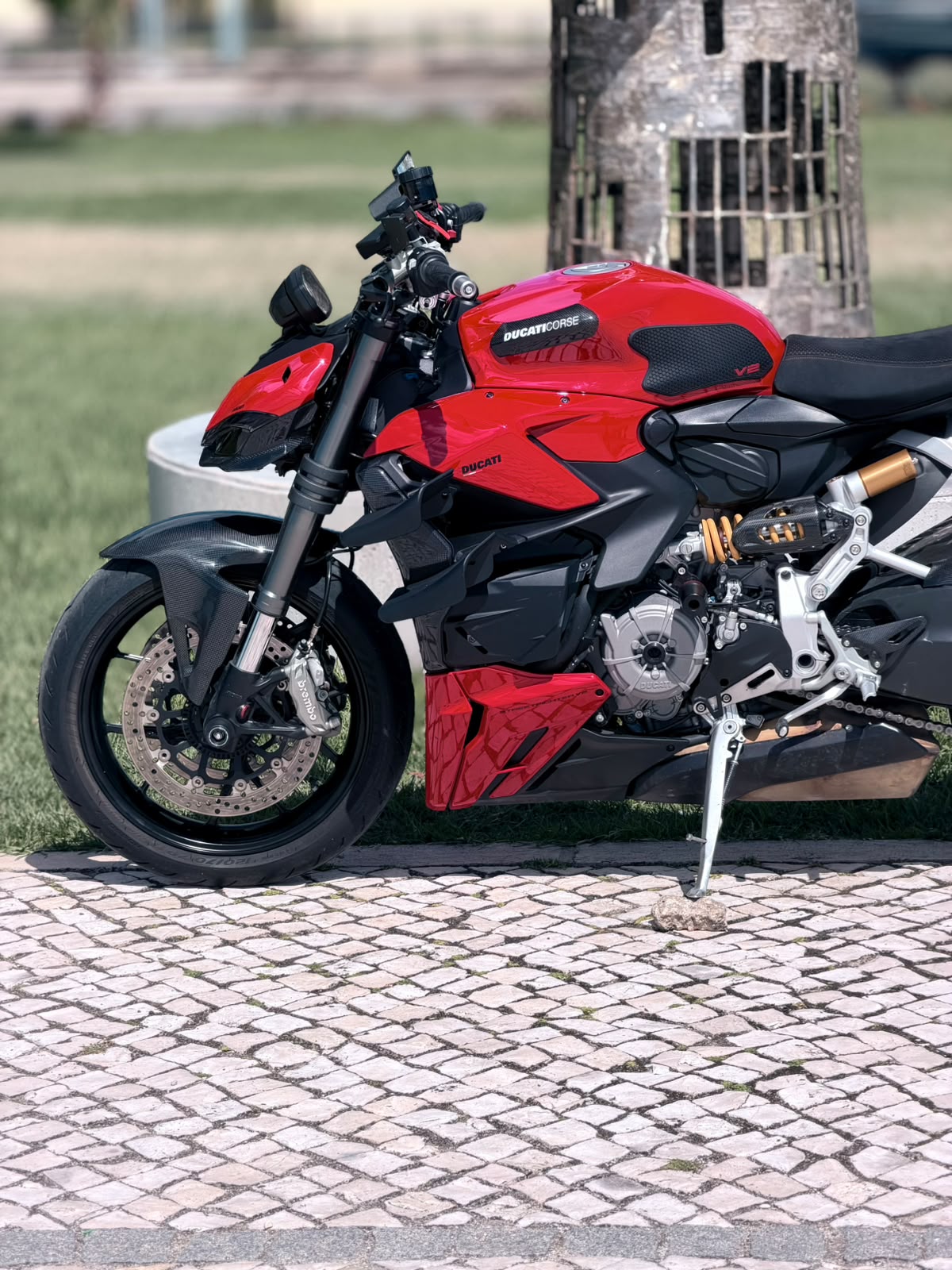 Ducati Streetfighter V2 vermelha estacionada em calçada portuguesa